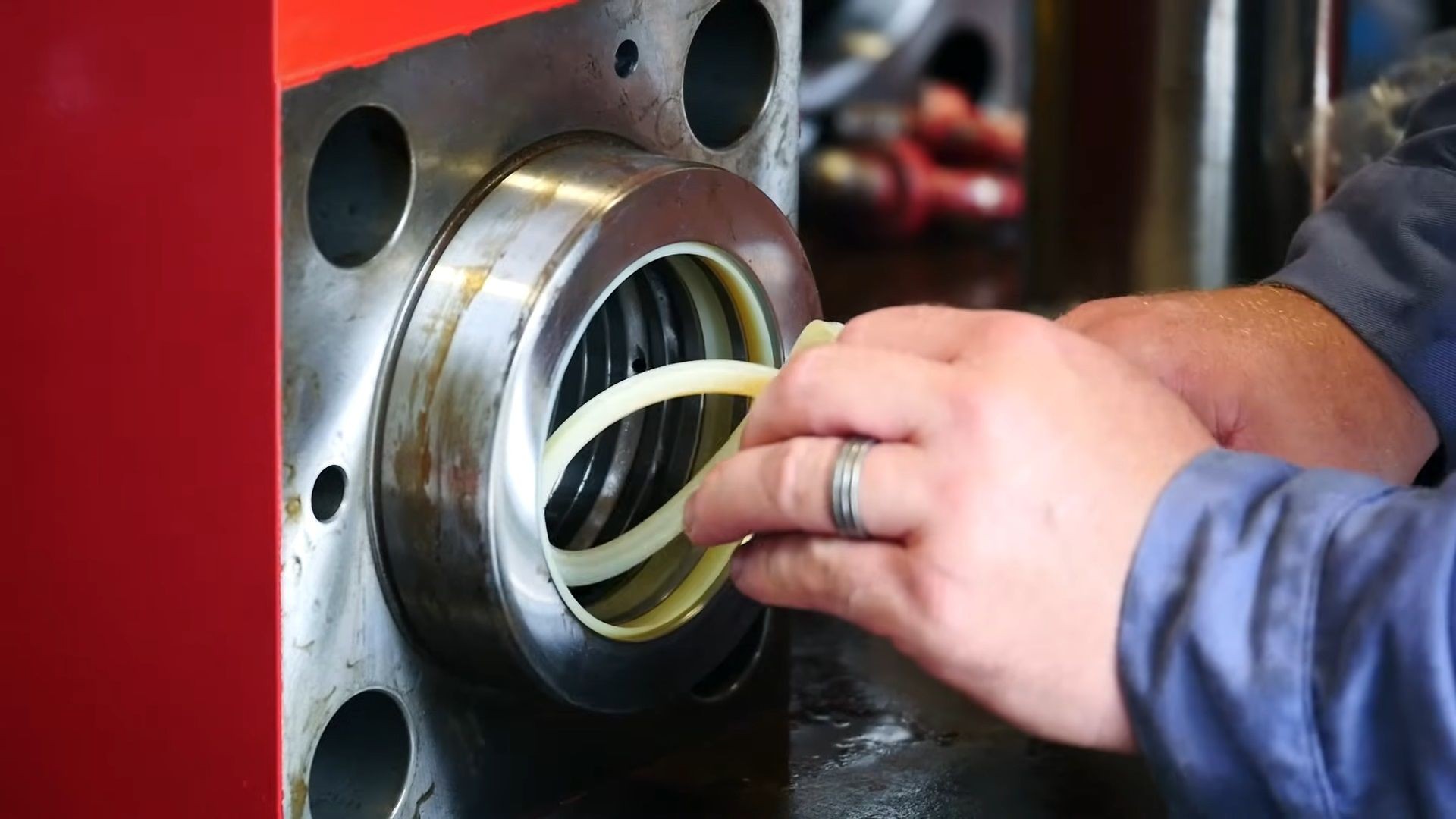 Close-up of a person installing a seal ring into a mechanical component with a red frame.